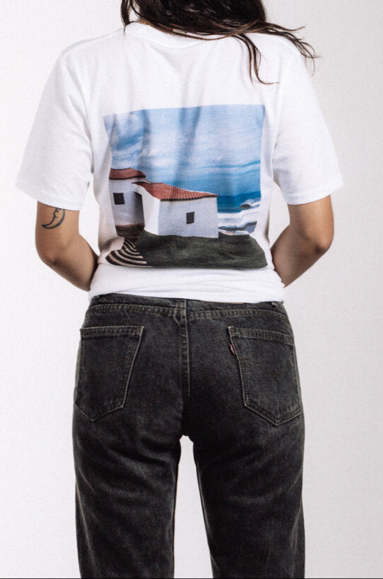 White Puerto band T-shirt with EP Portugal cover artwork featuring coastal building, ocean, and sky, photography by Julia Crowley, legendary surf photographer featured in Surfer Magazine